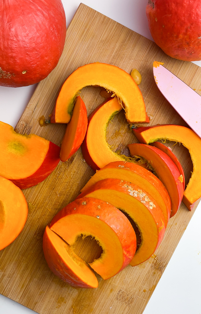 dynia pokrojona na ćwiartki i różowy nóż